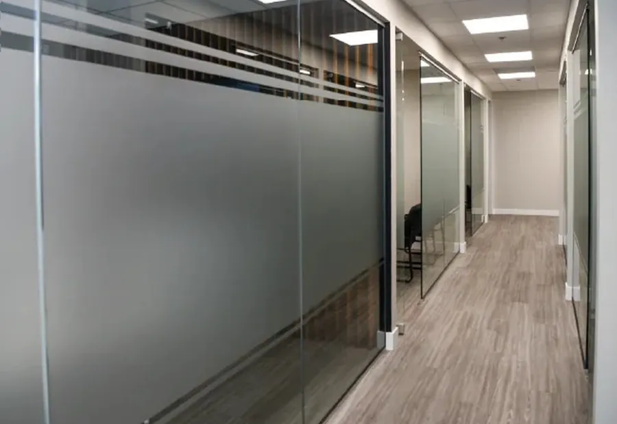 Frosted glass office partitions along a bright Calgary hallway, private but full of daylight